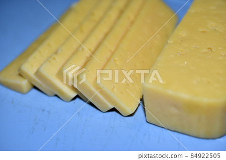 Pieces of juicy cheese cut on a cutting board 84922505
