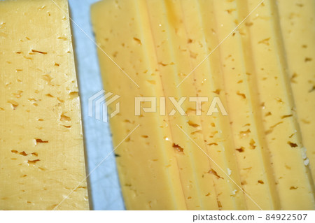 Pieces of juicy cheese cut on a cutting board 84922507