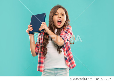 angry child hold book on blue background, school angry child hold book on blue background, school 84922796