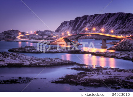 Bridge with illumination, snow covered mountains and blue sky 84923010