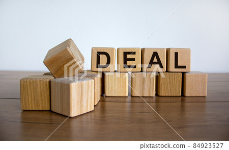 Concept word 'deal' on cubes on a beautiful wooden table. White background. Business concept. Copy space. Concept word 'deal' on cubes on a beautiful wooden table. White background. Business concept. Copy space. 84923527