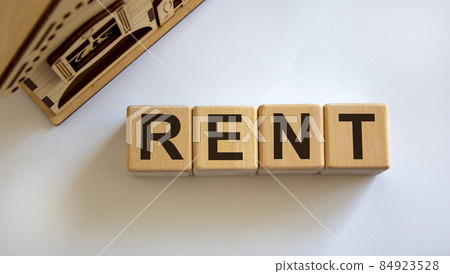 Wooden cubes form the word 'rent' near miniature house. Beautiful white background. Copy space. Business concept. Wooden cubes form the word 'rent' near miniature house. Beautiful white background. Copy space. Business concept. 84923528