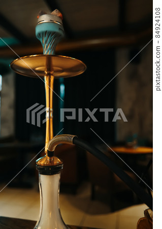 Gold hookah on table in lounge cafe. 84924108