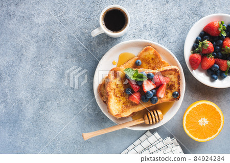 Sweet french toast with syrup and berries and cup of coffee 84924284