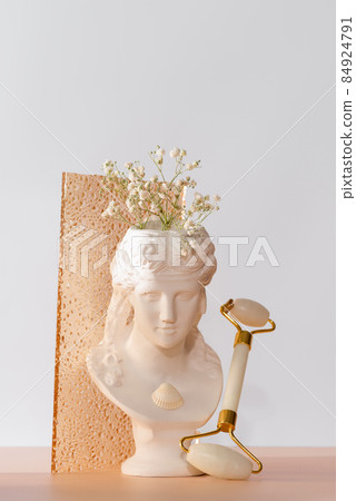 White marble head of a young woman with a face roller White marble head of a young woman with a face roller 84924791