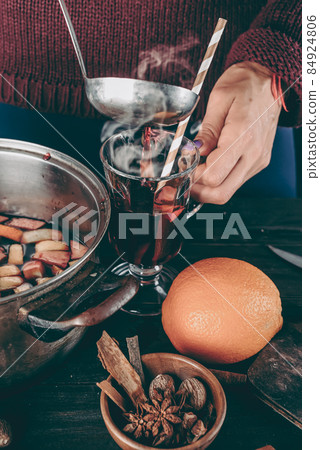 woman pouring hot mulled wine woman pouring hot mulled wine 84924806