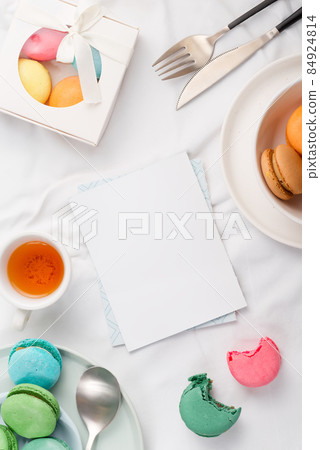Mockup paper blank and macarons with table setting on textile background 84924814
