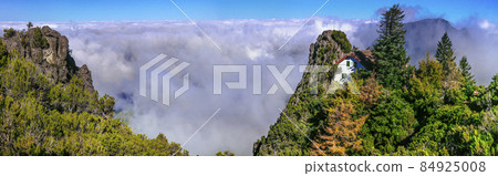 Hiking in Madeira island rocky mountains. Trail for Pico Ruivo highest point passing in the clouds 84925008