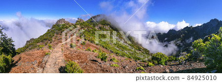 Hiking activity in Madeira island rocky mountains. Trail for Pico Ruivo highest point passing in the clouds 84925010