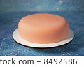 Delicious traditional pink mousse French cake for Christmas of strawberry on a frosty winter background of blue and white 84925861