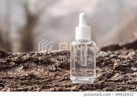 Cosmetic serum bottle mockup on tree bark background 84926932