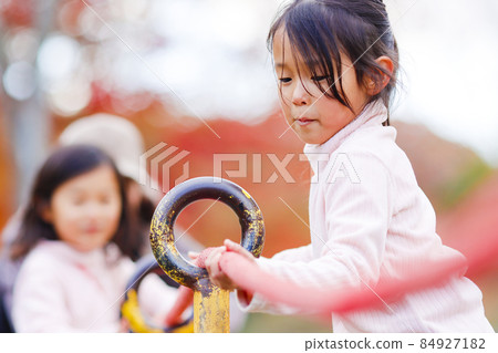Twin girls playing in the park 84927182