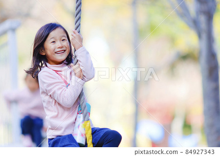 Twin sisters playing in the park 84927343