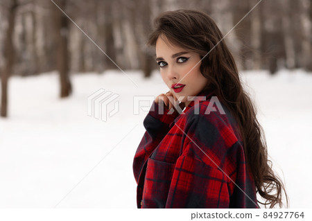 Woman with red lips in winter forest 84927764