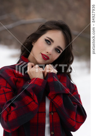Woman with red lips in winter forest Woman with red lips in winter forest 84927936