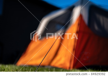 Selective focus on tent support rope leading up to the canvas to secure in-place Selective focus on tent support rope leading up to the canvas to secure in-place 84929392