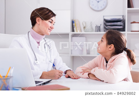 Doctor fills patient card for girl 84929802