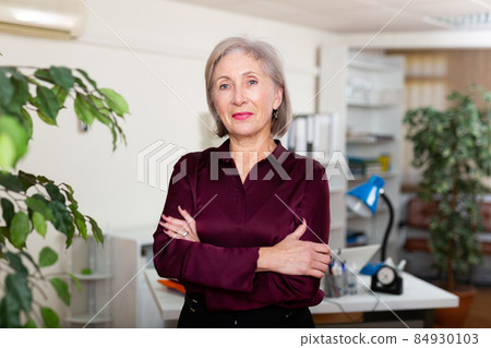 Businesswoman standing in office with document case 84930103