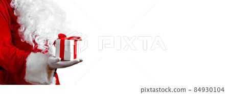 Santa Claus hand holding a wrapped Christmas present. 84930104