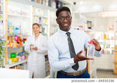Man holding bottle of cosmetic product 84930196