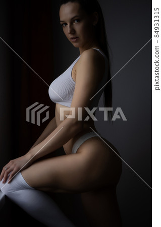 Alluring woman in underwear leaning on wall near window Alluring woman in underwear leaning on wall near window 84931315