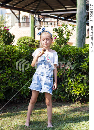 Little girl eating chocolate ice cream 84936147