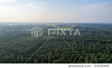 Aerial view with a drone of a spring wavy agricultural countryside landscape with plowed and Aerial view with a drone of a spring wavy agricultural countryside landscape with plowed and 84936409