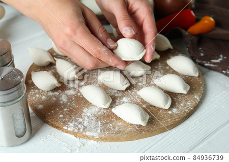 Concept of cooking vareniki or pierogi on white wooden table Concept of cooking vareniki or pierogi on white wooden table 84936739
