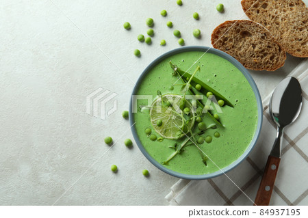 Concept of tasty eating with pea soup on white textured table Concept of tasty eating with pea soup on white textured table 84937195