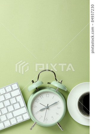 Workplace concept with alarm clock on green background Workplace concept with alarm clock on green background 84937230