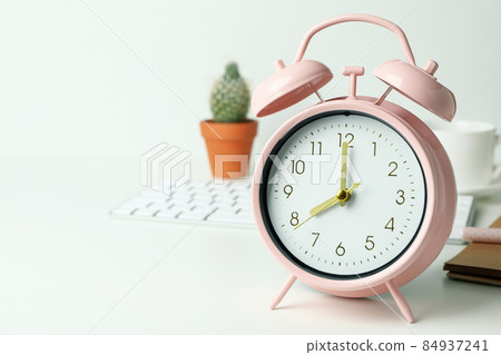 Workplace concept with alarm clock on white background Workplace concept with alarm clock on white background 84937241