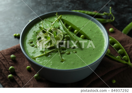 Concept of tasty eating with pea soup on black smokey table Concept of tasty eating with pea soup on black smokey table 84937292