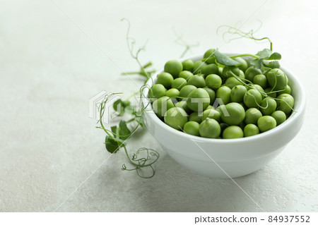 Bowl with pea seeds on white textured background Bowl with pea seeds on white textured background 84937552