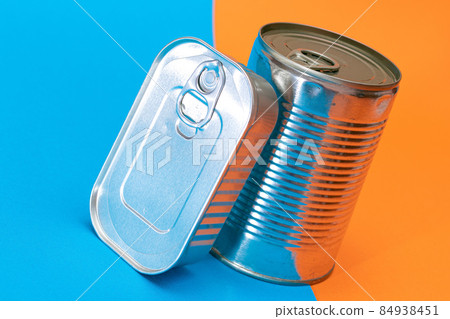 A Group of Stacked Tin Cans with Blank Edges on Split Blue and Orange Background 84938451