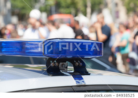 Police car flashing lights in focus, blurred people in background Police car flashing lights in focus, blurred people in background 84938525