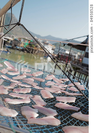 Vertical traditional Hong Kong old wooden house, sun dried fish, boat and river in countryside 84938528