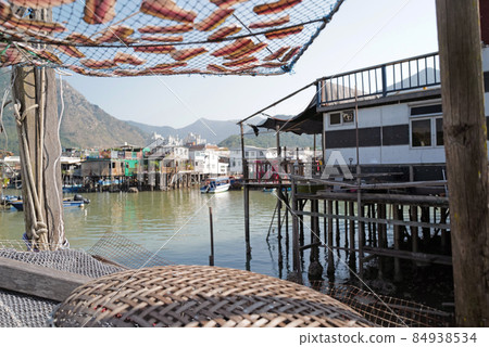 horizontal traditional Hong Kong old wooden house, sun dried fish, boat and river in countryside horizontal traditional Hong Kong old wooden house, sun dried fish, boat and river in countryside 84938534