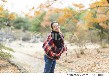 Female playing in the park of autumn leaves 84940005
