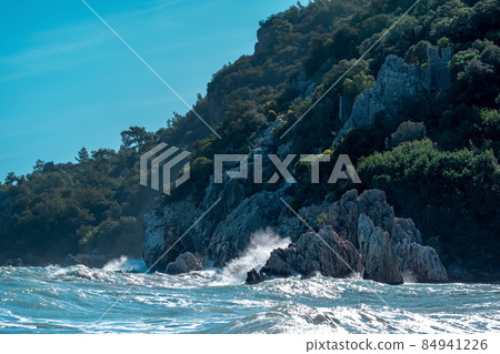 sea surf on a rocky wooded tropical seashore with fortress ruins 84941226