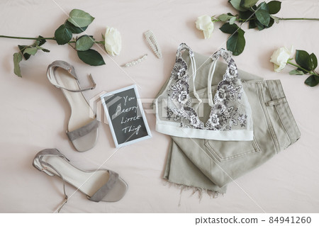 Women jeans, sandals, lingerie and flowers top view. Women's stylish spring summer outfit. Trendy clothes. Flat lay. Women jeans, sandals, lingerie and flowers top view. Women's stylish spring summer outfit. Trendy clothes. Flat lay. 84941260