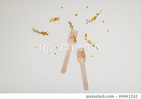 wood fork, bamboo cutlery and mimosa flowers on white background, zero waste, no plastic, eco-friendly concept 84941282