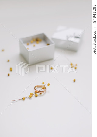 Box with golden engagement ring on flowers background, top view. Wedding, Marriage proposal concept 84941283