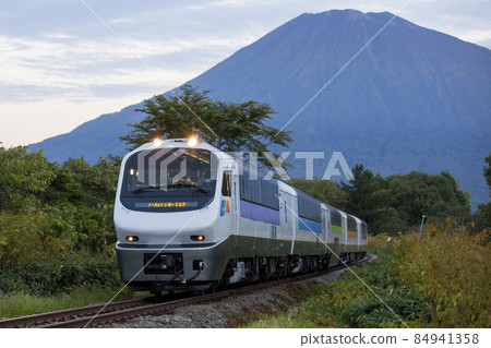 [Face blurred] Limited Express Niseko (North Rainbow Express) and Mt. Yotei at the Kita 4 Line railroad crossing 84941358