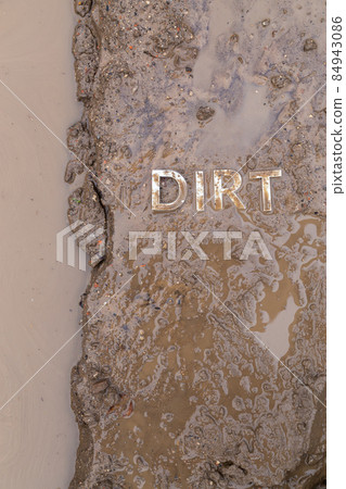 the word mud imprinted in wet dirt road surface - close-up with selective focus the word mud imprinted in wet dirt road surface - close-up with selective focus 84943086