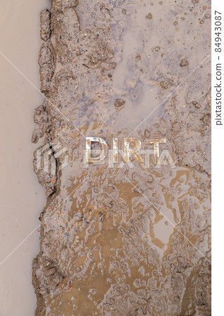 the word mud imprinted in wet dirt road surface - close-up with selective focus the word mud imprinted in wet dirt road surface - close-up with selective focus 84943087
