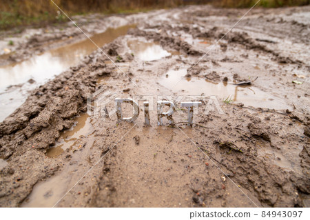 the word dirt composed of silver metal letters on wet clay surface the word dirt composed of silver metal letters on wet clay surface 84943097