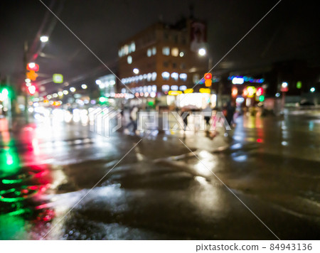 defocused night rain city street view with cars crossing road defocused night rain city street view with cars crossing road 84943136