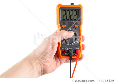 digit 2022 on lcd screen of digital electrical multimeter in left hand, isolated on white background 84943186