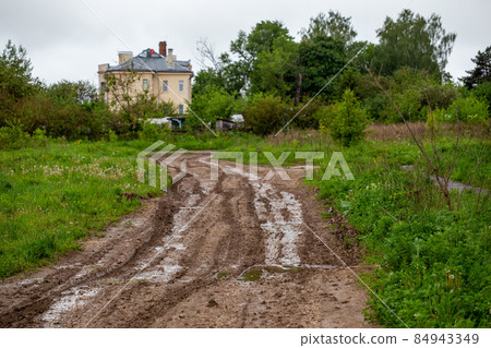 dirty clay mud road with puddles and tire tracks - closeup with selective focus and linear perspective dirty clay mud road with puddles and tire tracks - closeup with selective focus and linear perspective 84943349