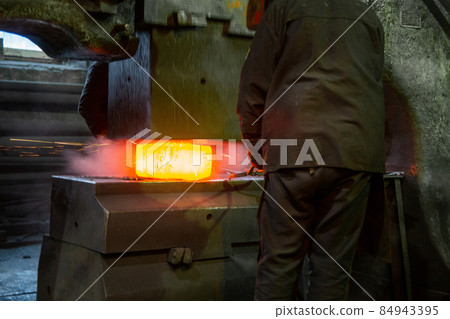 close-up picture of hot steel free forging process with big mechanical hammer machine 84943395